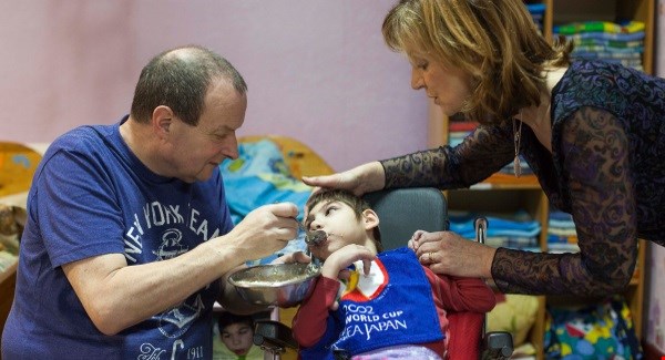 Cork Mayor Chris O'Leary and Adi Roche feed Masha in the Vesnova Children's Institution, Belarus. Picture: Claire Keogh